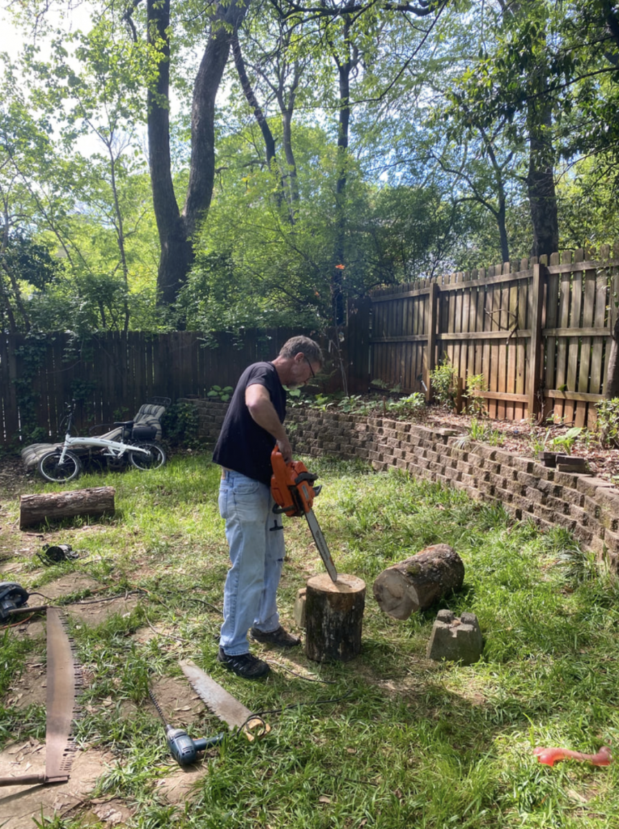 Associate Professor Hugh Crawford uses a chainsaw to begin building the planters out of the oak.